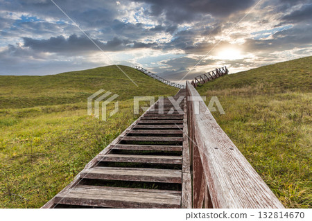 Wooden stairs across rolling green hills Wooden stairs across rolling green hills 132814670