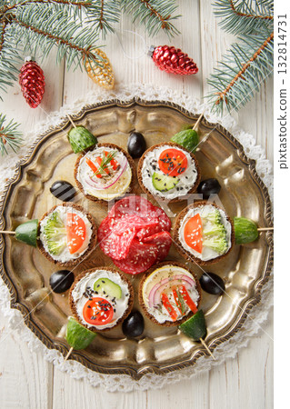 Christmas balls sandwiches with cream cheese and vegetables close-up in a plate. Vertical top view 132814731
