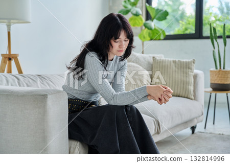 Unhappy upset tired young woman sitting on sofa at home 132814996