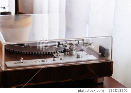 Vintage vinyl record player on table in living room at home. Vintage vinyl record player on table in living room at home. 132815391