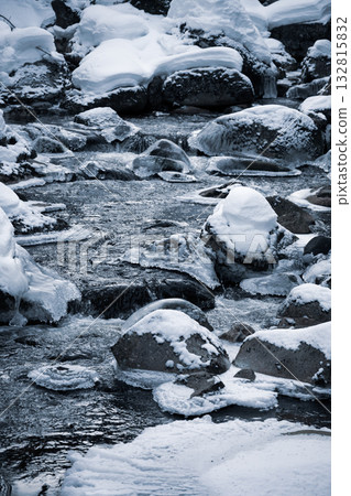 The Jizerka river flows gently through a winter landscape, surrounded by icy rocks and soft snow. The cold water creates a serene and tranquil atmosphere in the Czech countryside. The Jizerka river flows gently through a winter landscape, surrounded by icy rocks and soft snow. The cold water creates a serene and tranquil atmosphere in the Czech countryside. 132815832