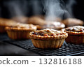 Freshly baked mince pies cooling on a wire rack, steam rising 132816188