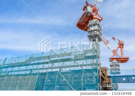 Construction site and crane against blue sky Construction site and crane against blue sky 132816498