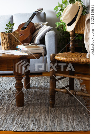 Rustic living room with straw hat on rattan chair. Natural light. Vertical real picture 132816682