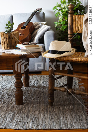 Cozy rustic living room with guitar and straw hat 132816684
