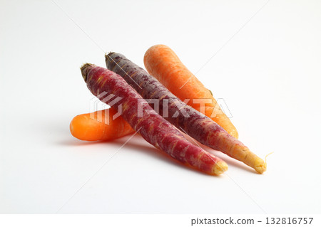 Black carrots and orange carrots over white background Black carrots and orange carrots over white background 132816757