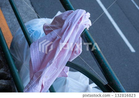 一件粉紅色襯衫繫在人行道欄桿上 132816823