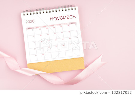 November 2026 desk calendar with pink pastel ribbon. November 2026 desk calendar with pink pastel ribbon. 132817032