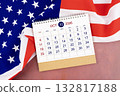 October 2026 Monthly desk calendar and United States of America flag. 132817188