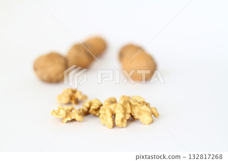 Peeled walnut closeup. Golden walnut kernel on a white background. Healthy foods. Selective Focus. Peeled walnut closeup. Golden walnut kernel on a white background. Healthy foods. Selective Focus. 132817268