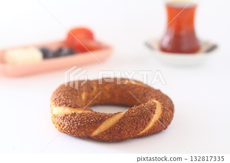 Turkish bagel, simit, tomatoes & Turkish tea on white background. Turkish bagel, simit, tomatoes & Turkish tea on white background. 132817335