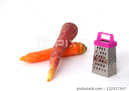 Black carrots and orange carrots over white background with little grater 132817347