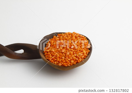 red lentils in wooden spoon isolated on white background. Top view. 132817802