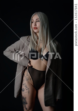 Model posing confidently in stylish attire against a dark background 132817841