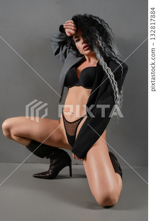 Sensual woman poses in lingerie and stylish jacket for striking fashion display 132817884