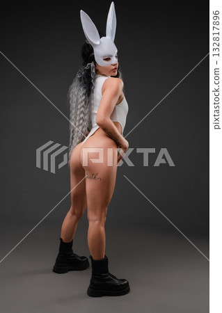 Woman in sensual lingerie with bunny mask and unique hairstyle poses confidently Woman in sensual lingerie with bunny mask and unique hairstyle poses confidently 132817896