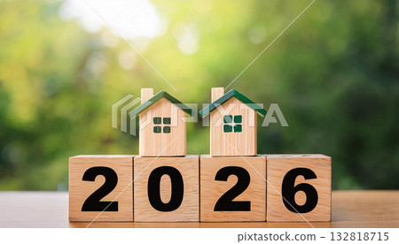 Two Wooden Houses with Green Roofs Sitting on 2026 Blocks Representing Real Estate Growth and Property Investment Two Wooden Houses with Green Roofs Sitting on 2026 Blocks Representing Real Estate Growth and Property Investment 132818715