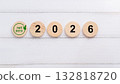 Green Net Zero Symbol on Wooden Circular Discs Displaying the Year 2026 132818720