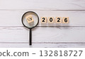 Black Graduation Cap Icon Under Magnifying Glass with Wooden 2026 Year Blocks 132818727