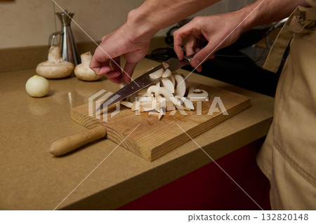 Slice To Perfection: Father And Child Chopping Mushrooms On a Wooden Cutting Board In The Kitchen Slice To Perfection: Father And Child Chopping Mushrooms On a Wooden Cutting Board In The Kitchen 132820148