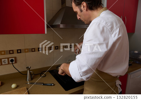 Chef In White Shirt Cooking Dinner In Modern Kitchen With Red Cabinets Chef In White Shirt Cooking Dinner In Modern Kitchen With Red Cabinets 132820155