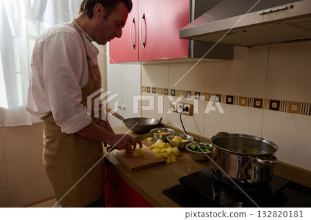 Father Cooking Soup in Kitchen While Child Helps Chop Potatoes and Prep Dinner 132820181