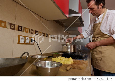 Family Dinner Prep: Father Cooking Soup While Child Helps in Cozy Kitchen 132820186