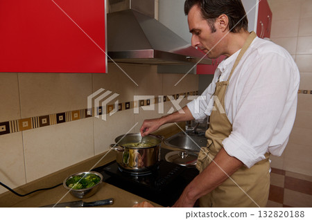 Father Cooking Soup in Modern Kitchen While Preparing Dinner 132820188