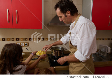 Father Cooking Soup While His Children Help In The Kitchen At Home 132820199