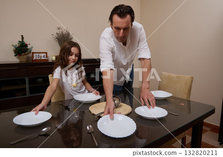 Father And Daughter Prepare Dinner Table In Cozy Home, A Warm Family Moment Father And Daughter Prepare Dinner Table In Cozy Home, A Warm Family Moment 132820211