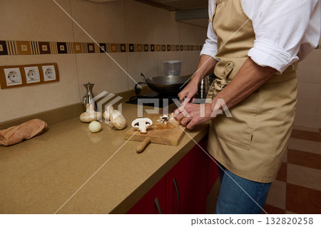 Father Cooking Soup in Kitchen While Daughter Helps Chop Mushrooms and Prepare Dinner Father Cooking Soup in Kitchen While Daughter Helps Chop Mushrooms and Prepare Dinner 132820258