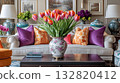 Elegant living room with vibrant tulips in a decorative vase and colorful cushions on a sofa 132820412