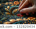 Woman's hand embroiders an Asian ornament on a carpet with gilded thread. Handmade 132820434