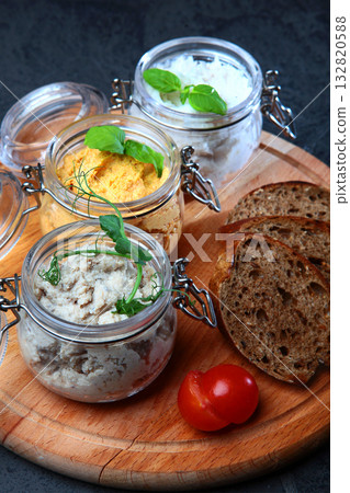 Pates in assortment are arranged in jars. Liver paste. Slices of rye bread. Healthy breakfast.Spectacular serving of dish. Pates in assortment are arranged in jars. Liver paste. Slices of rye bread. Healthy breakfast.Spectacular serving of dish. 132820588