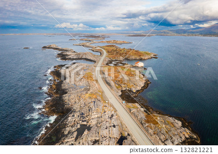 Magnificent Atlantic ocean road snakes across small islands and skerries. Grey sky and calm water emphasize vastness of Norwegian coastal landscape Magnificent Atlantic ocean road snakes across small islands and skerries. Grey sky and calm water emphasize vastness of Norwegian coastal landscape 132821221
