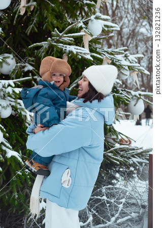 Winter Family Bonding by Snowy Christmas Tree 132821236