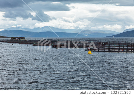 Open sea fish farm with mountain backdrop in Scotland Open sea fish farm with mountain backdrop in Scotland 132821593