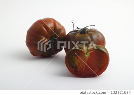 Black organic tomatoes with cuttings. Round black tomatoes. On a white background, isolated. 132821684