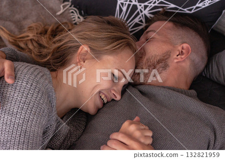 Loving couple cuddles and smiles in a cozy home setting. The scene reflects warmth, affection and the beauty of intimate connection. Loving couple cuddles and smiles in a cozy home setting. The scene reflects warmth, affection and the beauty of intimate connection. 132821959