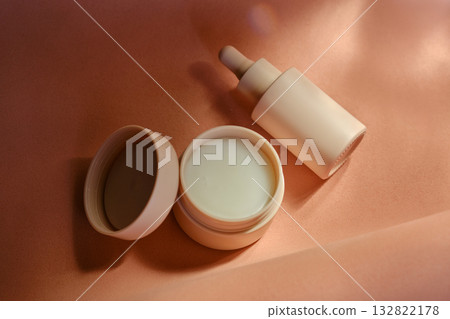 Face cream and serum on a soft beige background. Face cream and serum on a soft beige background. 132822178