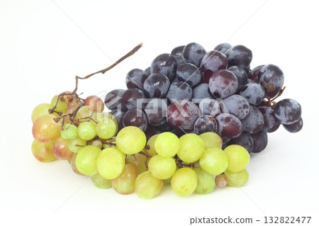 Black and green delicious grapes on a white plate close up 132822477