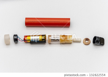 Disassembled electronic cigarette on a white background, the constituent elements of viper. Disassembled electronic cigarette on a white background, the constituent elements of viper. 132822554