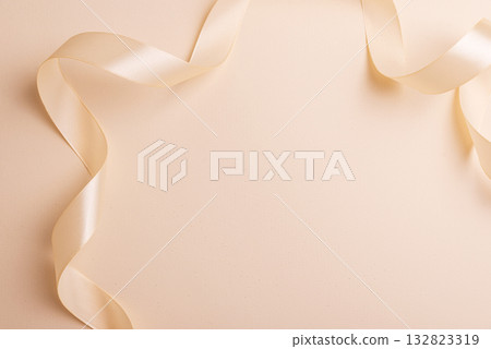 Elegant Satin Ribbon on Beige Background for Festive Design Elegant Satin Ribbon on Beige Background for Festive Design 132823319