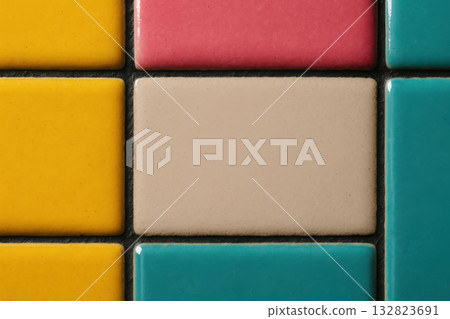 Colorful ceramic tiles arranged in a grid showcasing vibrant hues and unique textures in a close-up view 132823691