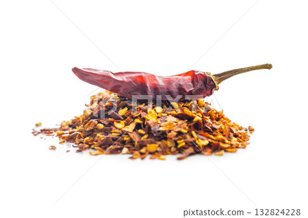 Red chili peppers flakes. Milled spicy peppers and dried chili isolated on white background. Red chili peppers flakes. Milled spicy peppers and dried chili isolated on white background. 132824228