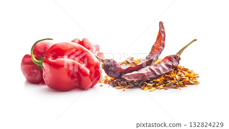 Red chili peppers flakes. Milled spicy peppers and habanero isolated on white background. Red chili peppers flakes. Milled spicy peppers and habanero isolated on white background. 132824229