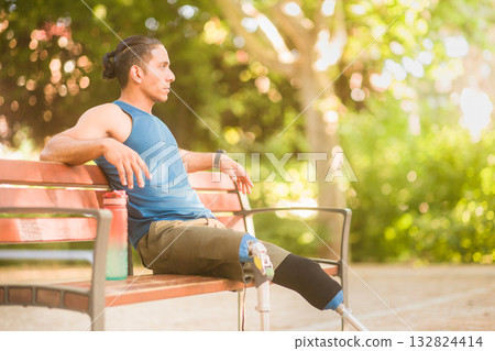 Disabled athlete resting on bench with prosthetic legs Disabled athlete resting on bench with prosthetic legs 132824414