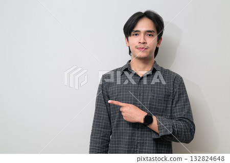 Portrait of handsome Young Asian Thai man pointing finger against white background 132824648