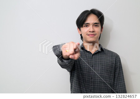 Portrait of handsome Young Asian Thai man pointing finger against white background 132824657