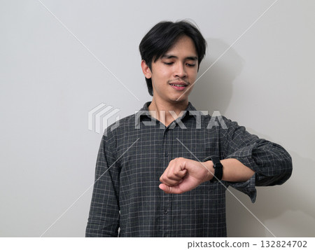 Portrait of handsome Young Asian Thai man using smartwatch against white background Portrait of handsome Young Asian Thai man using smartwatch against white background 132824702